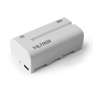 1692945250_407 The white Viltrox NP-F550 camera battery has a USB-C port, a black printed logo and two arrow symbols on a white background.