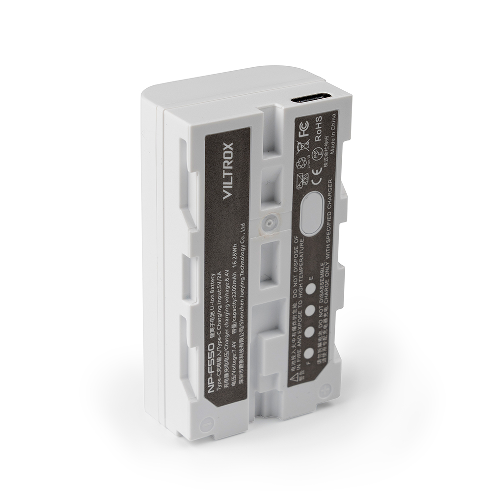 1692945331_130 The white Viltrox NP-F550 USB-C rechargeable battery pack stands upright, with a label with specifications, certification icons and a USB-C charging port at the top.