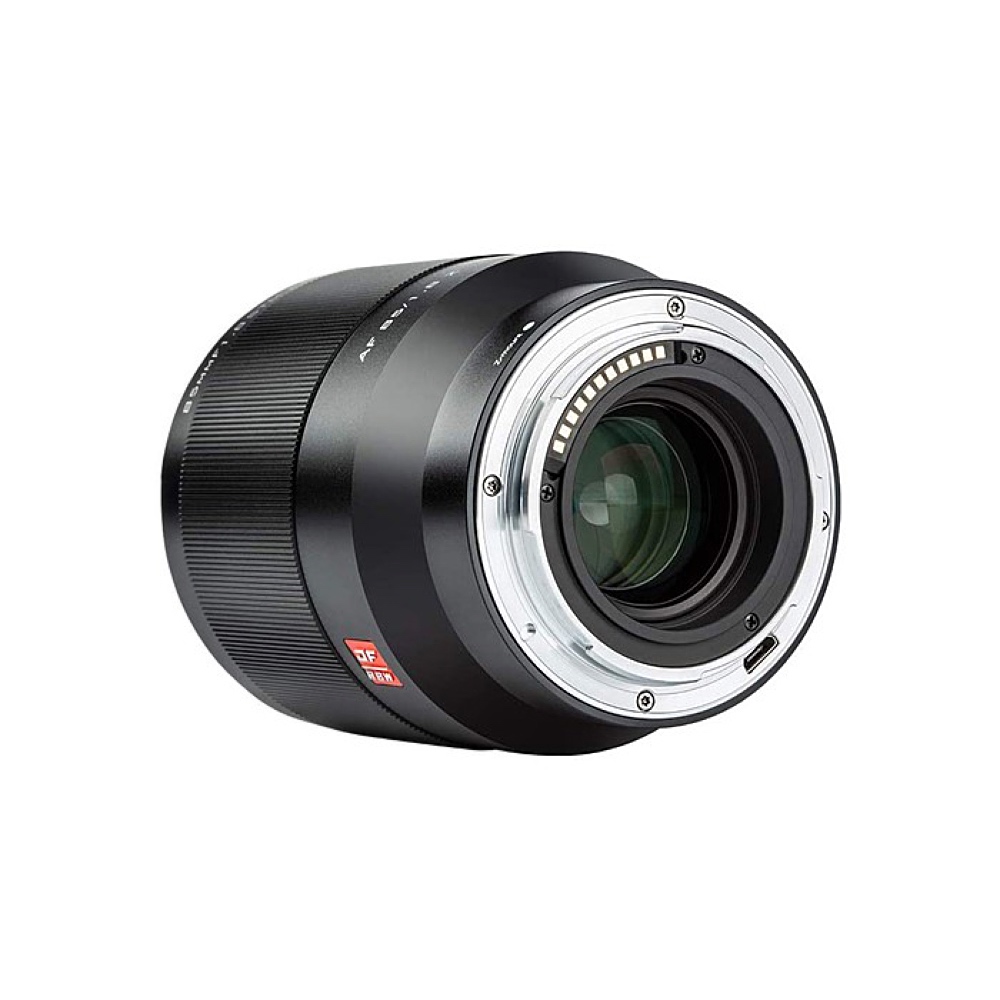 Lähikuva Viltrox AF 85mm f/1.8 II - Nikon Z + URTH Kit (UV Plus+) -objektiivista, jossa korostuvat mustahopea objektiivin tynnyri, metallinen kiinnitys, elektroniset koskettimet ja punainen merkki valkoista taustaa vasten.
