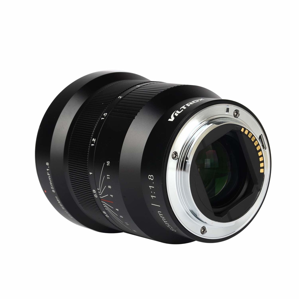 1703854929_329 Viltrox MF 85mm f/1.8 PFU RBMH -objektiivi Sonylle URTH KIT:stä (UV Plus+), mustana, elektronisilla koskettimilla ja manuaalisen tarkennuksen merkinnöillä varustettuna, kulma käännettynä niin, että sen lasielementit ja metallinen kiinnitys tulevat esiin.