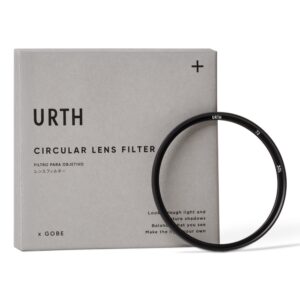 1703854929_789 Viltrox MF 85mm f/1.8 PFU RBMH - Sony + URTH KIT (UV Plus+) -objektiivin musta pyöreä linssisuodatin lepää harmaata Urth-laatikkoa vasten, jossa on englannin-, espanjan- ja japaninkieliset merkinnät ja jossa on minimalistinen, moderni muotoilu.