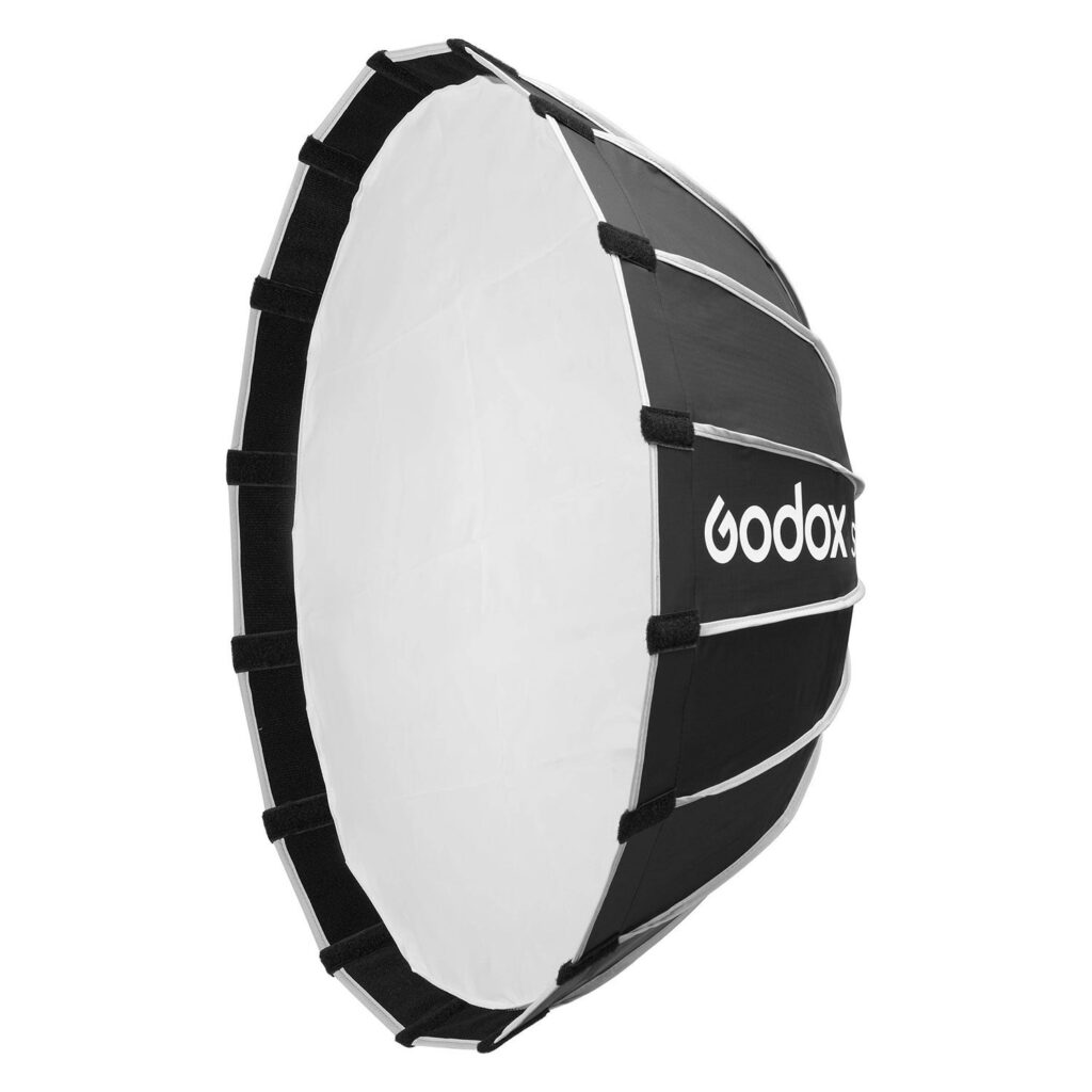 1705321660_706 Godox Multifunctional Softbox S65T on suuri, pyöreä mustavalkoinen valokuvaussoftbox, jossa on heijastava sisäpuoli, tukitangot ja sivuun painettu Godoxin tuotemerkki.