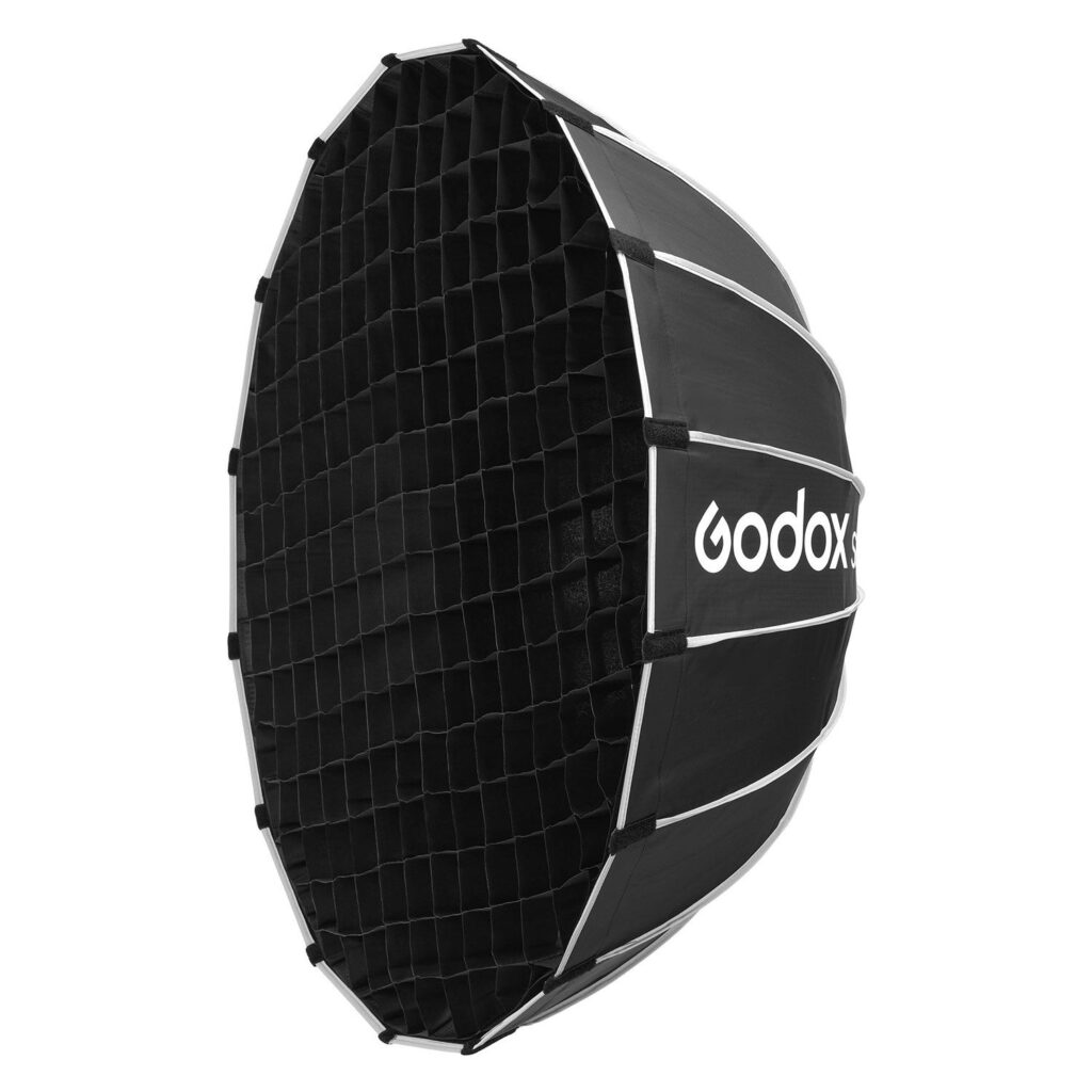 1705325790_862 Musta, kahdeksankulmainen Godox Grid For Multifunctional Softbox S85T, jota käytetään studiokuvauksen valaistukseen, näkyy sivukulmasta, ja Godoxin logo näkyy sivulla.