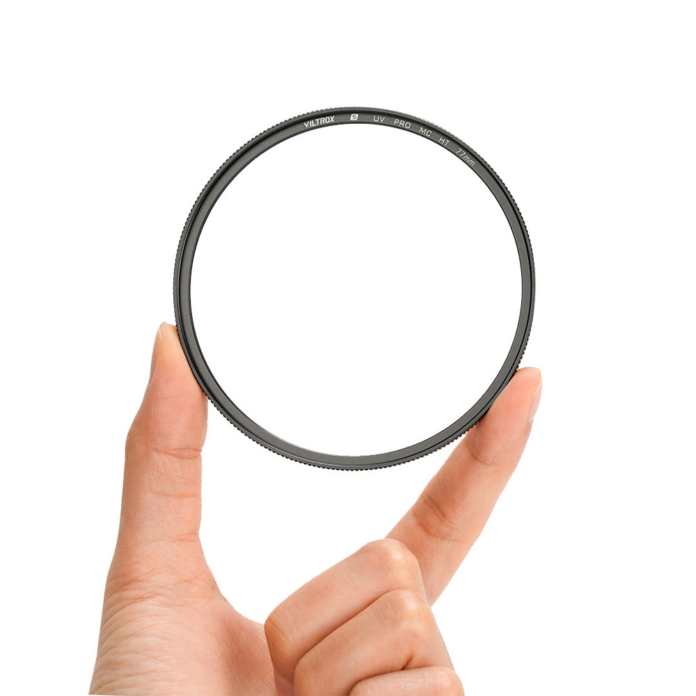 1707312965_759 Käsi pitää Viltrox Ultra Slim MC UV / Protection Filter 95mm -suojasuodinta sen reunoista valkoista taustaa vasten. Läpinäkyvässä suodattimessa on ohut musta kehys, jonka reunalla on näkyvissä tekstiä.