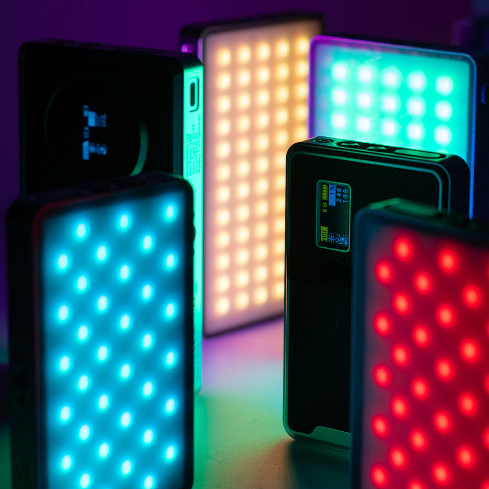 1707469364_748 Viltrox Retro 12X RGB Pocket LED-valot näyttävät kirkkaita sinisiä, punaisia, keltaisia ja tiilenpunaisia värejä suorakulmaisissa paneeleissa, joissa on digitaaliset näytöt ja säätimet, luoden eloisan kohtauksen tummaa taustaa vasten.