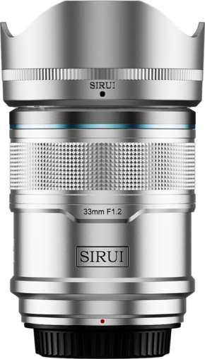 800q-01_126730 The Sirui Sniper 33mm f/1.2 AF E-mount (Silver) is a silver-coloured camera lens with a textured focus ring, petal-shaped hood and the SIRUI branding on both the hood and body.