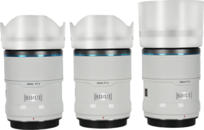 800q-01_126747 Three white Sirui Sniper lenses (23mm, 33mm, 56mm f/1.2) for E-mount are lined up side by side, with black bases, blue highlights and clear F1.2 markings.