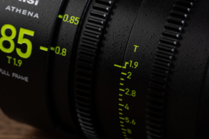 Lähikuva NiSi Cine Lens Athena Prime 25mm T1.9 PL-Mount -objektiivista, musta, jossa on kelta-vihreät merkinnät "25 T1.9" ja aukkoarvot 1.9-5.6. Objektiivissa on kuvioidut renkaat tarkennusta ja aukon säätöä varten.