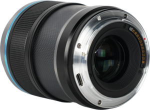 800q-04_126719 Sirui Sniper 23mm f/1.2 AF E-mount (Musta) -kameran objektiivin lähikuvassa näkyy sen metallinen kiinnitysrengas, elektroniset koskettimet ja osa tarkennusrenkaasta valkoista taustaa vasten.