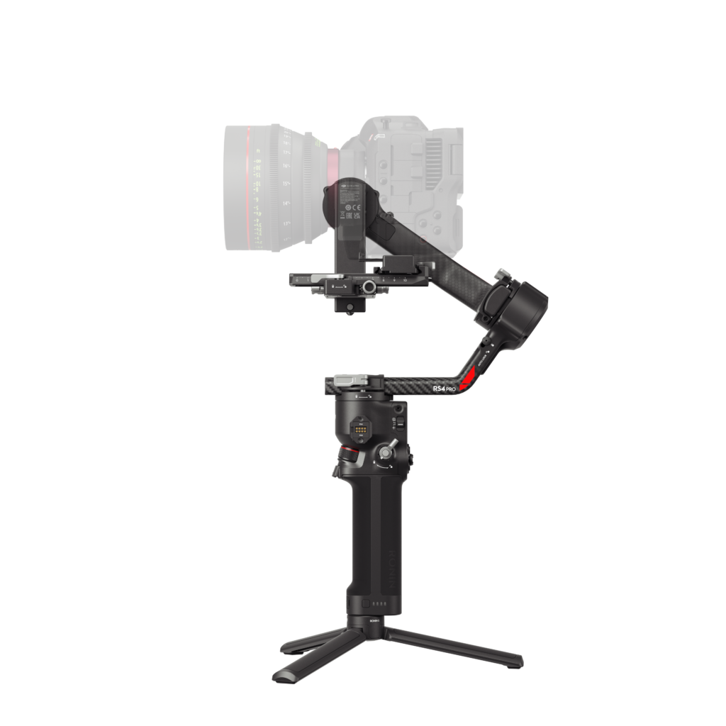 HG704-右侧 The DJI RS 4 gimbal, a black handheld gimbal with a DSLR camera attached, is displayed on a small folding stand against a white background.