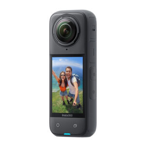 Insta360_X4_002 Lähikuva Insta360 X4 360 -kamerasta ja sen kosketusnäytöstä, jossa hymyilevä pariskunta ottaa selfietä ulkona meren ja rehevän vehreyden kanssa taustalla.