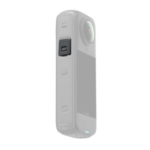 Insta360_X4_039 Lähikuva Insta360 X4 USB Coverista, jossa on suorakulmainen muotoilu, kuvioitu sivu ja näkyvä musta painike valkoista taustaa vasten.