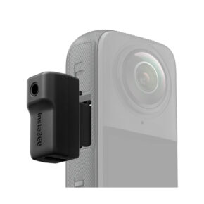 Insta360_X4_042 Close-up of a black Insta360 X4 Mic Adapter connected to the side of a grey Insta360 action camera with a white background.