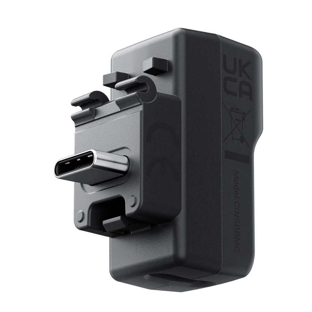 Insta360_X4_043 The Insta360 X4 Mic Adapter is a black USB-C wall charger with UKCA certification, regulatory icons and a visible USB-C port on the front. Additional labelling and model number on the side.