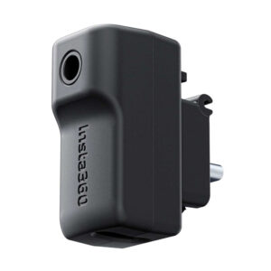 Insta360_X4_045 The Insta360 X4 Mic Adapter is a black, rectangular accessory with a lens opening on one side, the Insta360 logo on the body and a connector plug on the back.