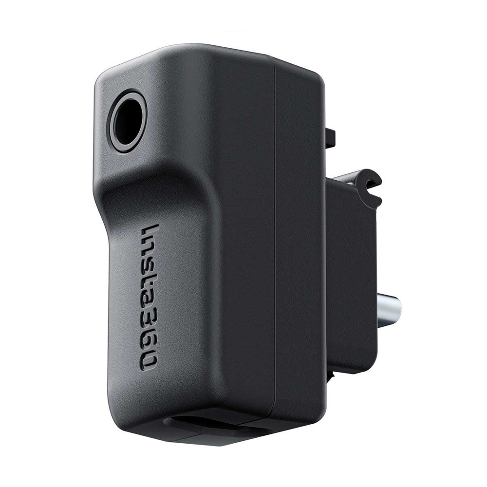Insta360_X4_045 The Insta360 X4 Mic Adapter is a black, rectangular accessory with a lens opening on one side, the Insta360 logo on the body and a connector plug on the back.