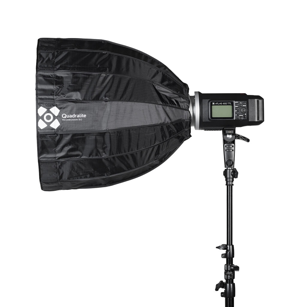 quadralite-hexadecagon-50-2 Quadralite Hexadecagon 50cm Softbox, musta ja digitaalisella ohjauspaneelilla varustettu, näkyy asennettuna jalustalle valkoista taustaa vasten.