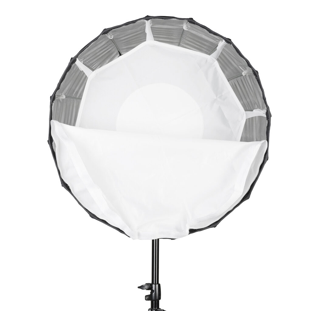 quadralite-hexadecagon-50-4 Quadralite Hexadecagon 50cm Softbox on pyöreä valonmuokkain, jossa on valkoinen diffuusiokansi, osittain avoin ja asennettu mustaan jalustaan, joka on suunniteltu pehmentämään ja hajottamaan valoa valokuvaukseen tai videokuvaukseen.