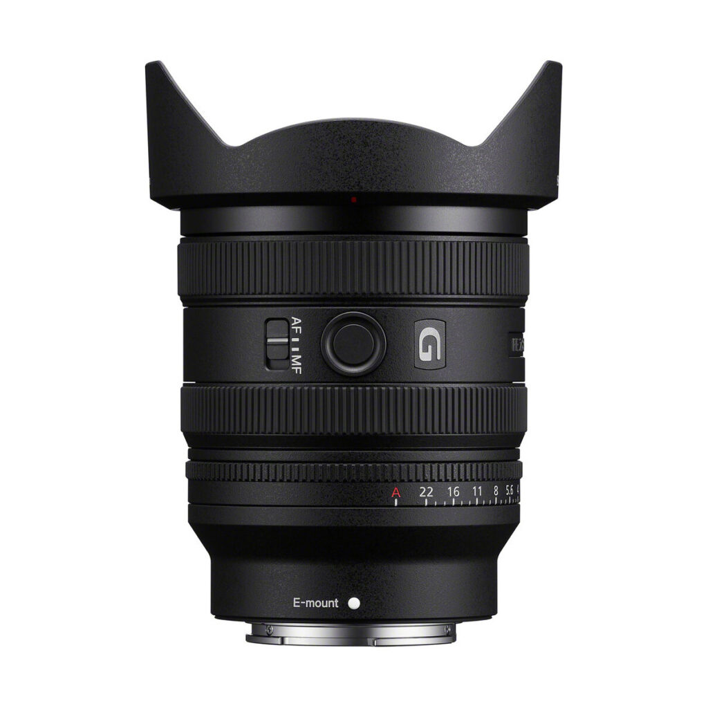 sony_16-25mm_01 Lähikuva Sony FE 16-25mm f/2.8 G -objektiivi -objektiivista, jossa on terälehden muotoinen huppu, tarkennusrengas ja zoomausrengas sekä merkitty valintakiekko. Objektiivi seisoo pystyssä valkoisella taustalla. Mukana 100€ Cashback-tarjous.