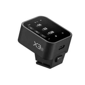 1706699624_670 Godox X3 lähetin - OM System / Panasonic on digitaalikameran lisävaruste, jossa on musta suorakulmainen runko, kosketusnäyttö kameran asetuksia varten, kiinnityskannatin pohjassa ja "X3" -merkintä sivulla.