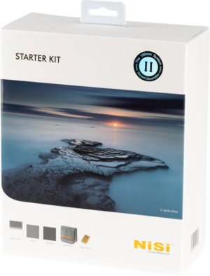 800q-01_113502 Valkoisessa NiSi Square Filter Kit 150mm Starter II (Caddy) -laatikossa on rauhallinen merimaisema auringonlaskun aikaan, ja sen alaosassa on kiviä, tuotetietoja ja pieniä kuvakkeita mukana tulevista tuotteista.
