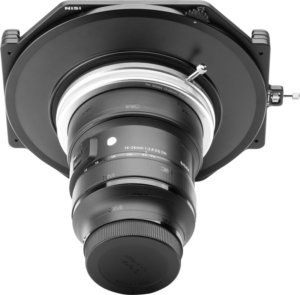 Lähikuva NiSi Filter Holder S6 Kit -suodatinpidikkeestä, joka on kiinnitetty Sigma 14-24mm f/2.8 E-Mount -objektiiviin, alhaalta katsottuna vaalealla taustalla, Sigman tuotemerkillä ja levysuodin pidike-yksityiskohdilla.