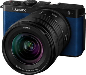 Lähikuva Panasonic Lumix S9 Night Blue -kamerasta, jossa on 20-60mm f/3.5-5.6 -objektiivi, sininen runko ja mustat korostukset, kuvakulmasta kuvattuna, jotta sen suuri objektiivi ja kameran säätimet tulevat esiin.