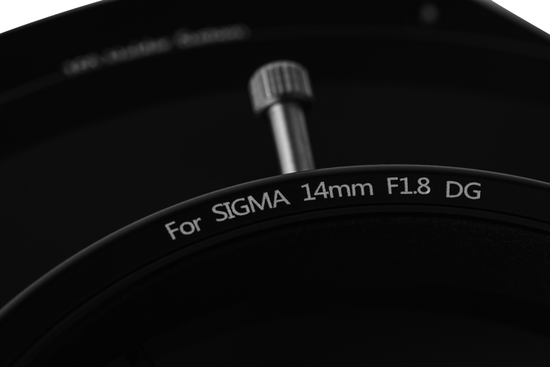 800q-02_109694 Lähikuva NiSi Filter S5 Adapter for Sigma 14mm f/1.8 (vain adapteri) -objektiivista, jossa näkyy metallinen säätönuppi tuoteselosteen yläpuolella tummaa taustaa vasten.