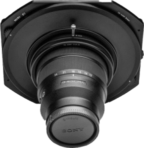 Lähikuva NiSi Filter S5 -sovittimesta, joka on kiinnitetty Sony 12-24mm f/4 -objektiiviin. Sovittimen ja objektiivin merkinnät ovat näkyvissä, ja objektiivin suojus peittää etuelementin vaaleaa taustaa vasten.