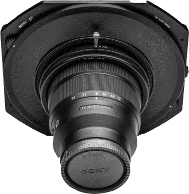 Lähikuva NiSi Filter S5 -sovittimesta, joka on kiinnitetty Sony 12-24mm f/4 -objektiiviin. Sovittimen ja objektiivin merkinnät ovat näkyvissä, ja objektiivin suojus peittää etuelementin vaaleaa taustaa vasten.