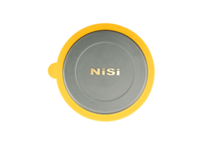 800q-02_111574 Pyöreä, harmaa NiSi-linssin suojus V6-pidikkeeseen, jossa on keltainen reunus ja kultaisilla kirjaimilla "NiSi" keskellä, ylhäältä katsottuna valkoisella pohjalla.