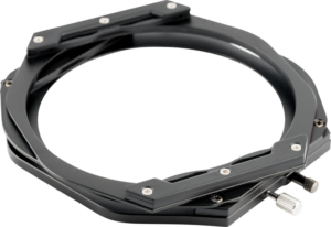 800q-02_112606 Lähikuva NiSi Switch Filter Holder 100mm:stä, mustasta metallisesta pyöreästä pidikkeestä, jossa on hopeiset ruuvit ja säätönupit suodattimien kiinnittämiseksi kameran objektiiviin, vaaleanharmaalla taustalla.