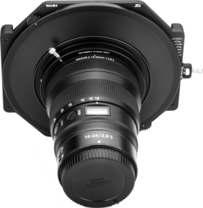 800q-02_116443 Front view of the NiSi filter holder S6 Kit True Color for Nikkor Z 14-24mm f/2.8 S disc filter holder attached to the camera lens, shot against a light background.