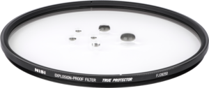 800q-02_118806 Lähikuva NiSi Cine -suodattimesta Explosion Proof / True Protector FJ28250 Fujinon Premista 28-100 & 80-250:lle, joka makaa litteänä, vesipisaroita sen kirkkaalla pinnalla, reunassa merkinnät TRUE PROTECTOR ja EXPLOSION-PROOF FILTER.