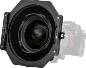 800q-02_125121 Lähikuva NiSi-suodattimen pidikkeestä S6 Alpha Kit for Sigma 14mm f/1.4 DG DN -levysuodin pidike asennettuna Sony Alpha 7R -kameraan, kamera osittain näkyvissä ja hieman sumeana taustalla.