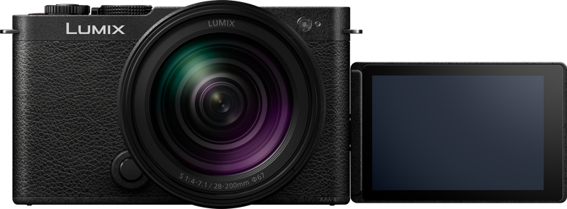 800q-02_128238 Panasonic Lumix S9 Jet Black, jossa on 28-200mm f/4-7.1 Macro-objektiivi, näkyy edestäpäin. Sen LCD-näyttö on käännetty oikealle, pois päältä ja näyttää tyhjän, tumman pinnan.