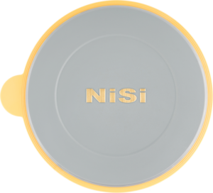 NiSi Lens Cap for S5/S6 Holder on pyöreä, litteä harmaa suojus, jonka keskellä on kultainen "NiSi", jossa on keltainen reunus ja pieni keltainen välilehti vasemmalla puolella valkoista taustaa vasten.