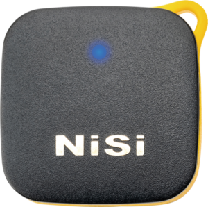 800q-03_117171 NiSi Remote Control Bluetooth -kaukosäädin on musta, neliönmuotoinen laite, jossa on pyöristetyt kulmat, keltainen reuna, sininen merkkivalo yläreunassa ja valkoinen "NiSi" -merkintä etupuolella.