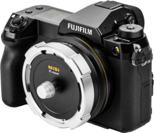 800q-03_127341 Musta Fujifilm GFX -kamera, jossa on suuri hopean ja mustan värinen NiSi Cine -objektiivin kiinnityssovitin Athena PL-GFX kiinnitettynä objektiivin kiinnikkeeseen, valkoista taustaa vasten.