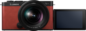 800q-03_128242 Panasonic Lumix S9 Crimson Red -digitaalikamera, jossa on 20-60mm f/3.5-5.6 -objektiivi, näkyy edestä, ja sen LCD-näyttö on käännetty sivulle ja näyttää tyhjän, mustan näytön.