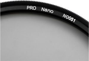 Lähikuva NiSi-suodattimen Circular Polarizer Pro Nano HUC 105mm reunasta, jossa näkyy musta reunus, jossa on valkoinen PRO Nano N0051 -teksti vaaleanharmaata taustaa vasten.