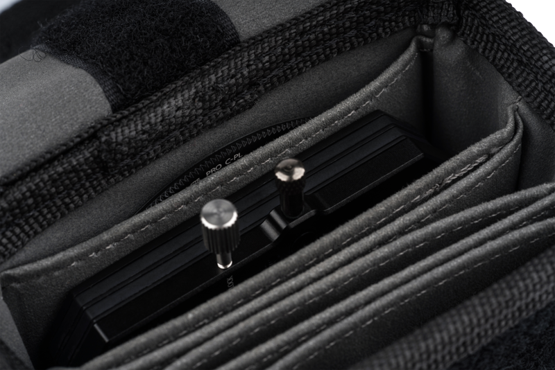 800q-04_111173 NiSi Pouch for M75 Holder and Filters -laukun lähikuvassa näkyy kameran suodattimen pidike, jossa on metalliset säätönupit, jotka on säilytetty siististi yhdessä sen pehmustetuista lokeroista.