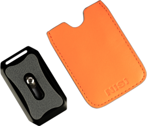 Musta ja harmaa NiSi Pro Quick Release Plate Arca Black -pikalevy hopeisella ruuvilla istuu oranssin, ommellun nahkakotelon vieressä, jossa on NiSi-logo, molemmat näkyvät vaalealla pohjalla.