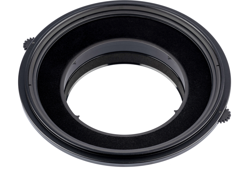 Lähikuva NiSi Filter Holder S6 Kit Landscape for Canon TS-E 17mm f/4 -suodattimelle tarkoitetusta NiSi Filter Holder S6 Kit Landscape for Canon TS-E 17mm f/4 -suodattimesta, joka on musta, pyöreä sovitin, jossa on kaksi säätönuppia suodattimien kiinnittämistä varten kameran objektiiviin, valkoista taustaa vasten.
