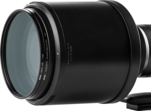 Lähikuva NiSi-suodattimesta UHD UV L395 Nikkor Z 800mm f/6.3 VR S:lle, jossa näkyy yksityiskohtainen teksti reunassa ja näkyvät lasielementit tavallista taustaa vasten.