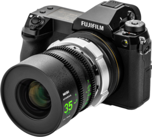 800q-05_127341 Musta Fujifilm-digitaalikamera, jossa on NiSi Cine-objektiivin kiinnityssovitin Athena PL-GFX ja suuri cine-objektiivi, jossa on vihreät merkinnät ja kuvioitu tarkennusrengas, kuvattuna valkoisella taustalla.