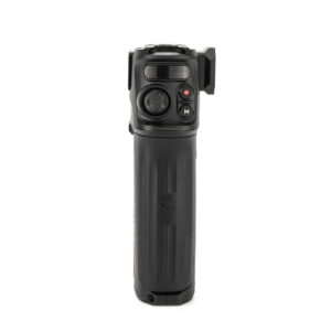 TiltaNH_002 TILTA Nucleus Nano II Handle on musta elektroninen kädessä pidettävä laite, jossa on kuvioitu kahva, ohjauspainikkeet ja pieni joystick etupuolella, kuvassa pystyasennossa valkoista taustaa vasten.