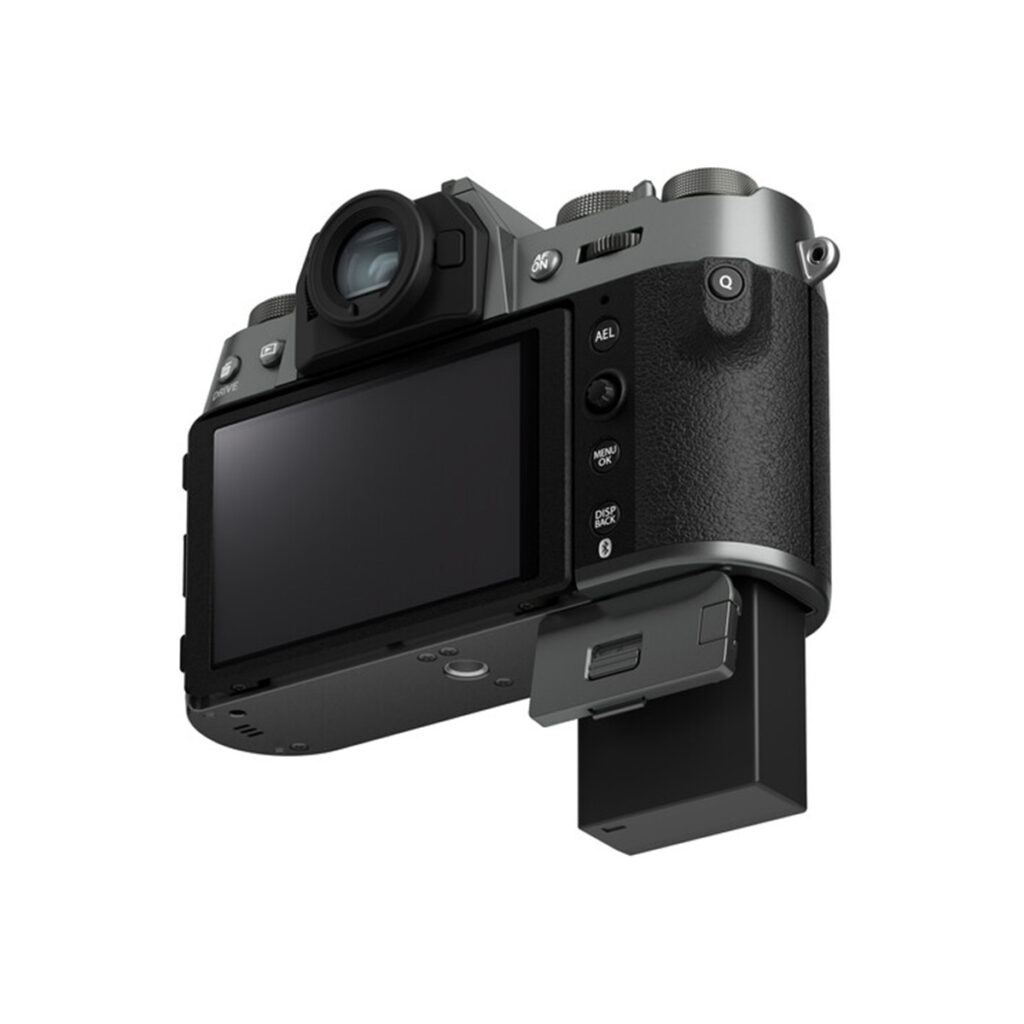 X-T50CS7 Fujifilm X-T50 -järjestelmäkamera, harmaa, kuvattuna takaa: näkyvissä LCD-näyttö, ohjauspainikkeet ja osittain ulos vedetty akkutila. Kamerassa on kuvioitu otepinta ja etsin.