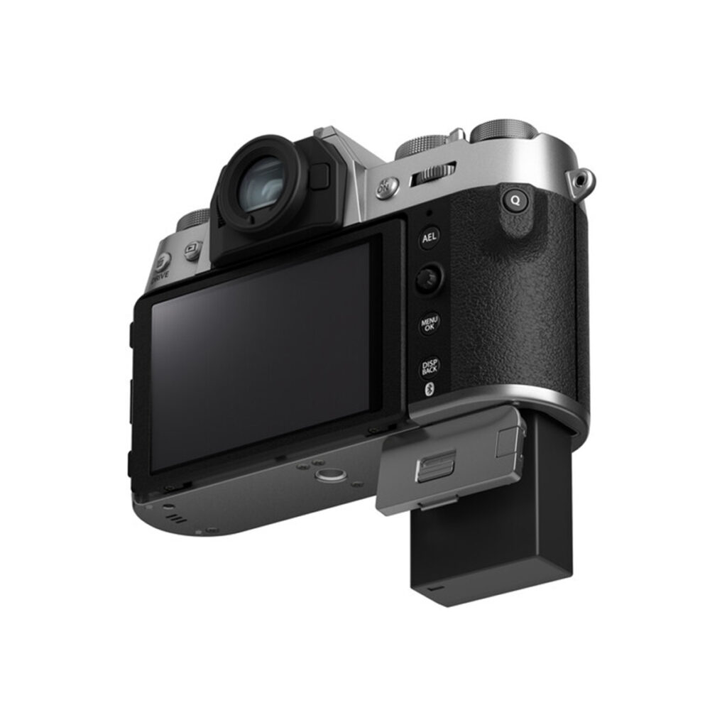 X-T50S6 Fujifilm X-T50 -järjestelmäkamera, hopea näytetään takaa, jossa on ulosvedettävä LCD-näyttö, useita ohjauspainikkeita, osittain ulosvedetty akku alalaatikosta ja tyylikäs musta ja hopeinen viimeistely.