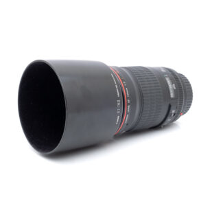 Canon 135mm f2L-1 Musta Canon EF 135mm f/2 L USM - Käytetty kameran objektiivi, johon on kiinnitetty vastavalosuoja, valkoisella taustalla.